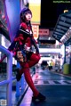 A woman in a red and black outfit is posing for a picture.